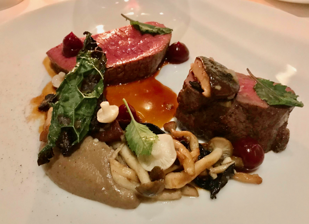 Seared lamb at Cafe Boulud at Four Seasons Toronto served medium rare with a glossy jus, wild mushrooms, and smooth vegetable puree, accented with fresh herbs and jewel toned garnishes. The refined plating and rich flavours create an elegant fine dining experience perfect for valentine’s day in Canada.