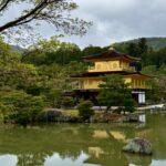 View of Kinkakuji from the front with trees framing the picture.