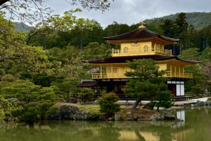 View of Kinkakuji from the front with trees framing the picture.