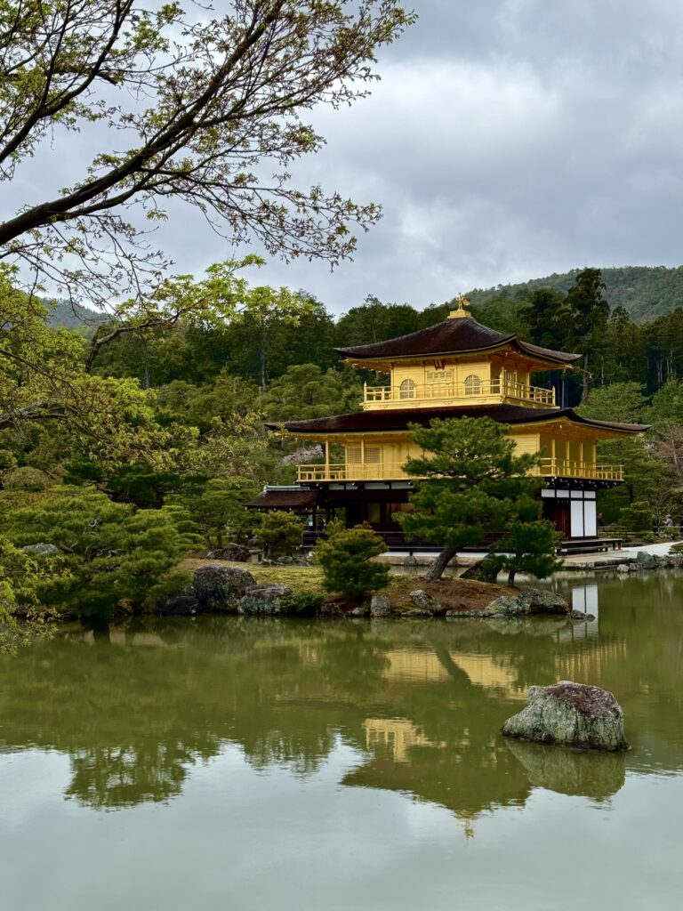 View of Kinkakuji from the front with trees framing the picture.