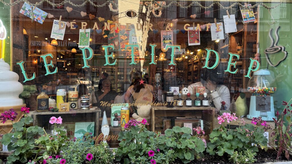 Alt text: The charming storefront of Le Petit Dep, a café and general store in Montreal, features colorful flowers, vintage decor, and handwritten signs in its window display. This cozy, Instagram-worthy spot is a local favorite among unique places to eat in Montreal.